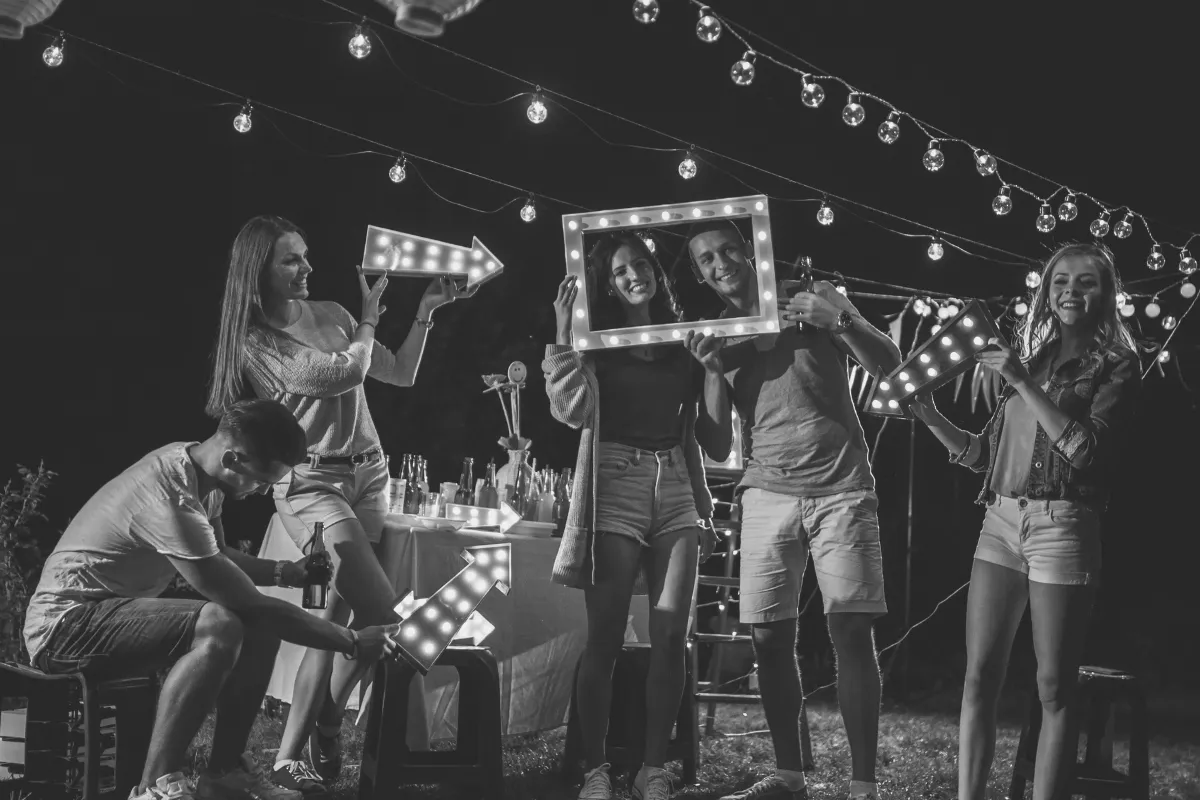 Sommerfest bei Dämmerung, geschmückt mit Lichterketten, während ein fröhliches Fotoshooting die Stimmung einfängt.